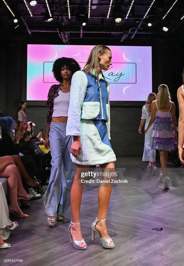 Models walking down the runway at a fashion show.