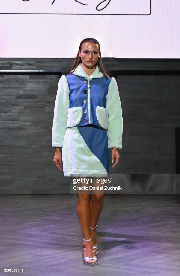Model walks runway in blue and white fur outfit.