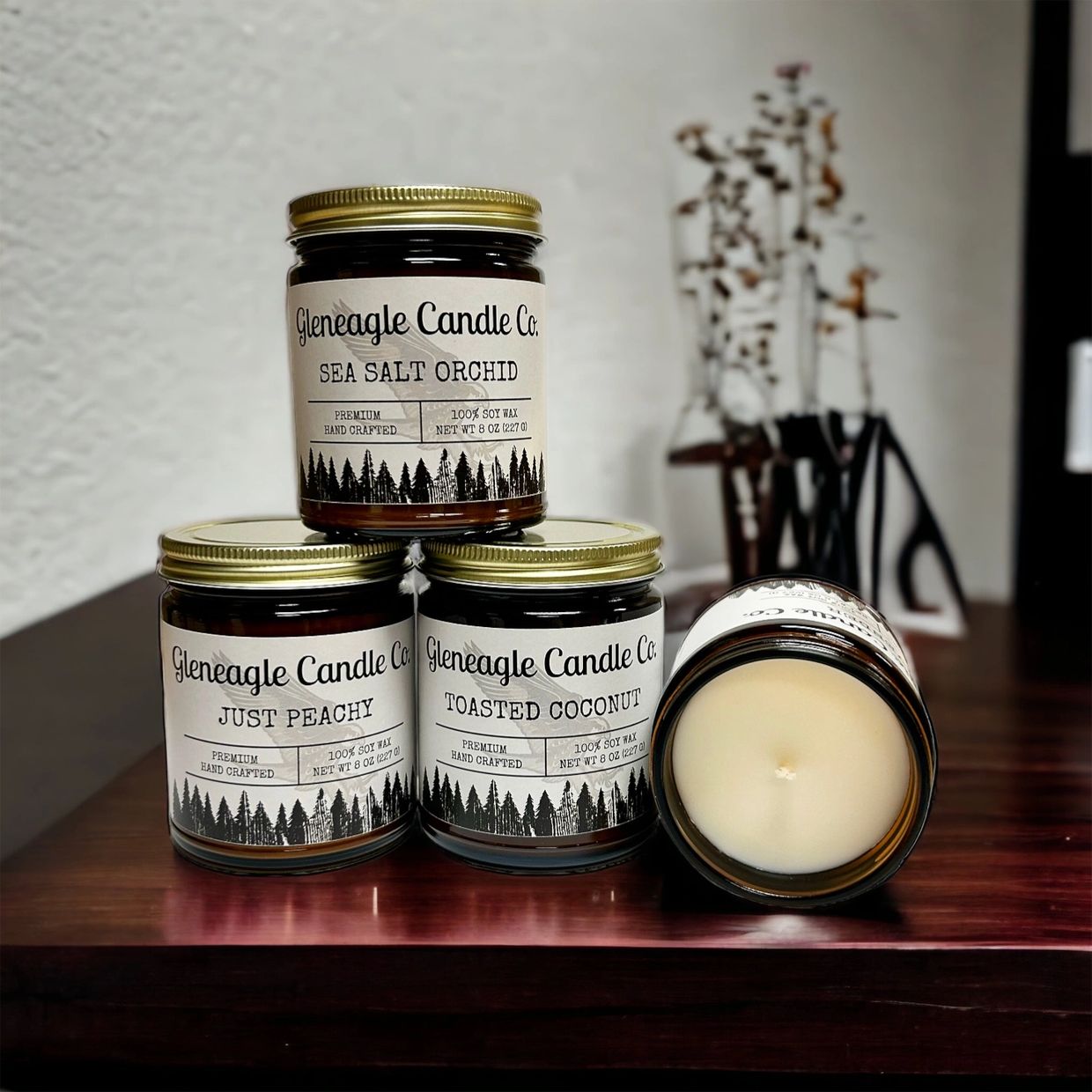 Selection of 8 ounce candles with gold lids in various scents. 