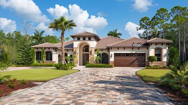 Luxurious Mediterranean-style house with a tiled roof and lush landscaping.