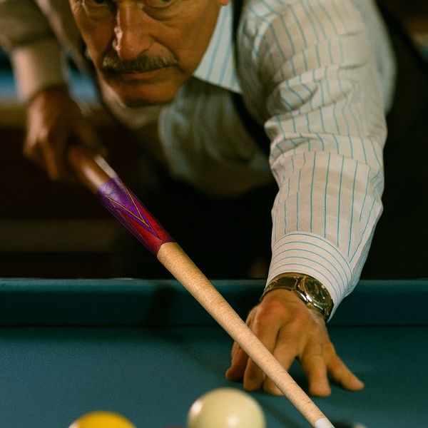 Focused man aiming a billiard shot with a cue stick on a pool table.