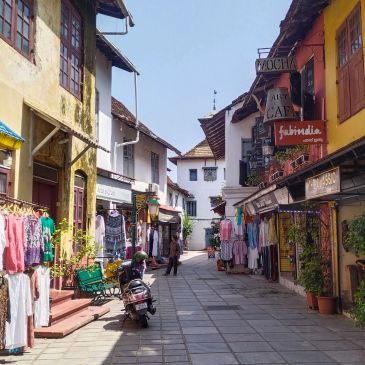 Quiet street with shops and colorful clothes displayed.