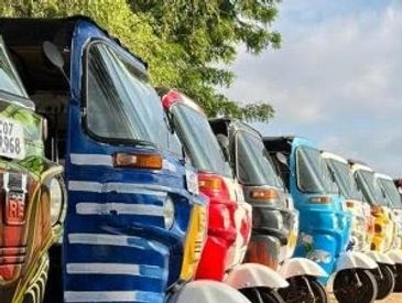 Colorful auto rickshaws lined up outdoors.
