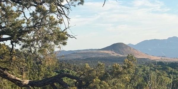 Scenic view of mountains and forest under a partly cloudy sky.