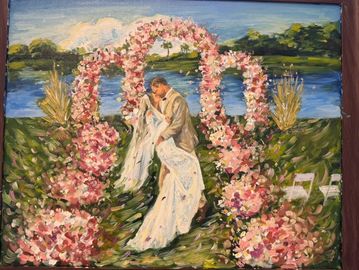 A romantic wedding kiss under floral arches by a lakeside.