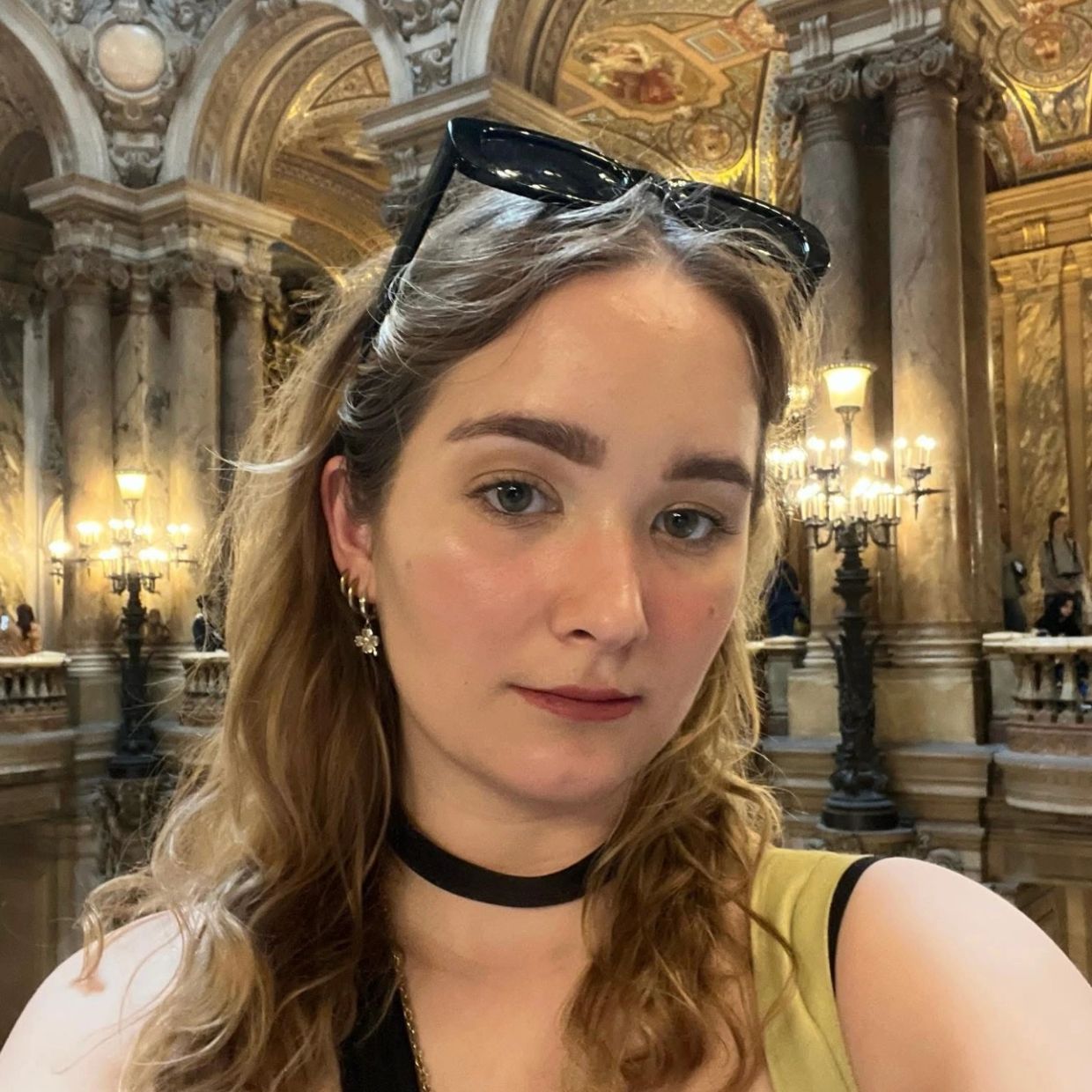 Young woman taking a selfie in a grand, ornate hall.