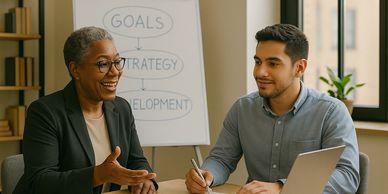 An experienced advisor guiding a younger professional with a whiteboard.