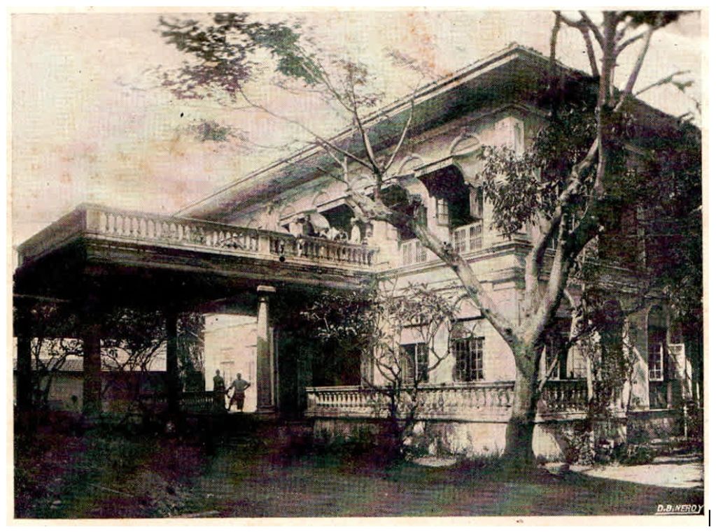 Old large house with trees and pillars.