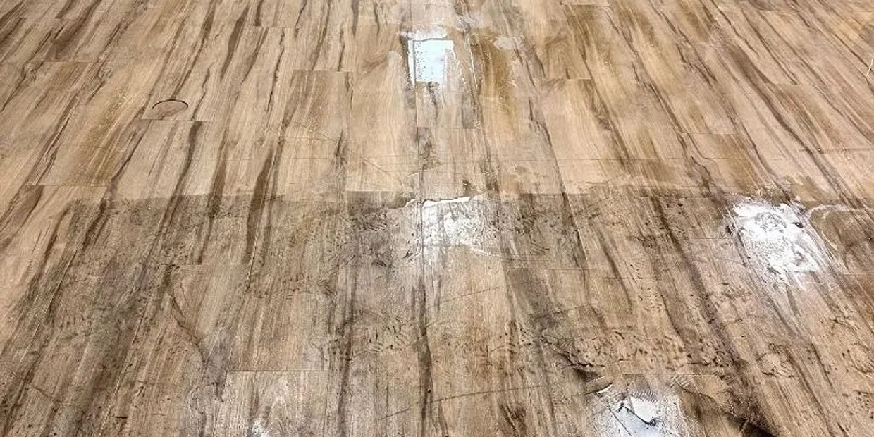Wooden floor with a visible streak of wet cleaning.