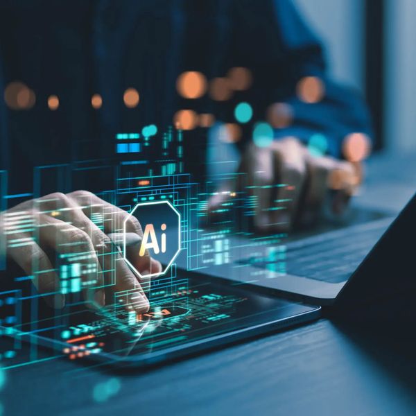 Person interacting with AI interface on a digital device beside a laptop.