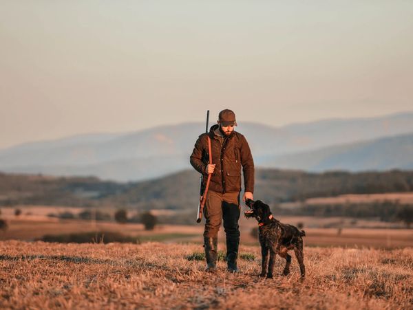 Lone hunter walking with dog