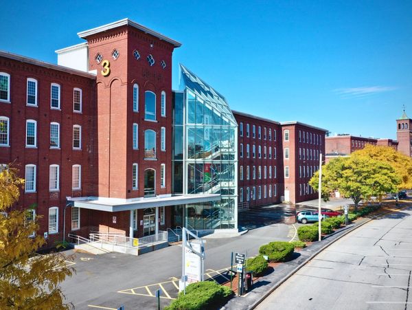 A large brick building with glass entrance under a clear blue sky.
