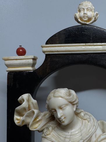 Detailed sculpture of a woman with cherub and apple.