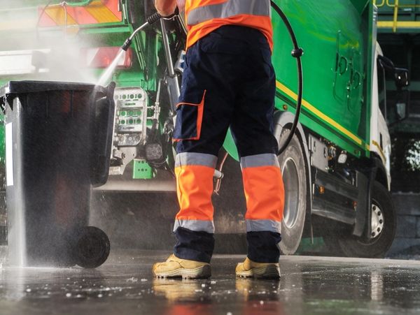 man cleans the residential bin