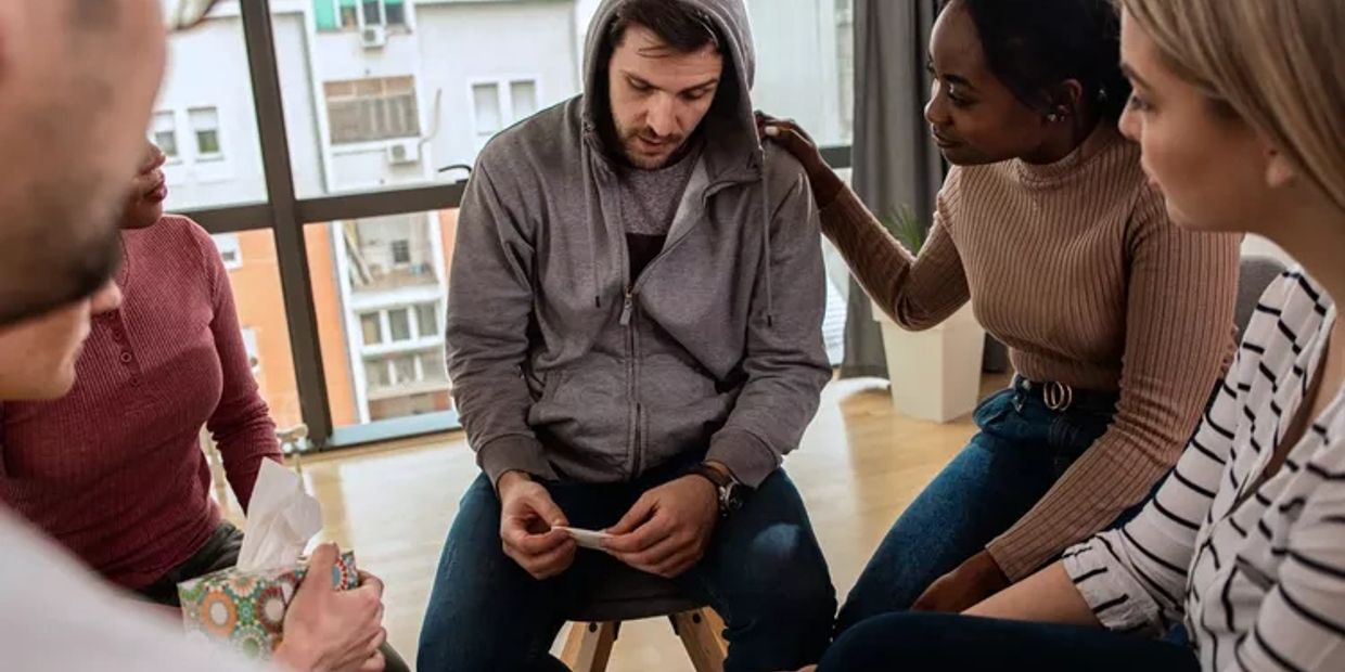 Group therapy session with supportive friends.