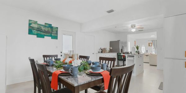Dining table set for a meal in a bright kitchen area.