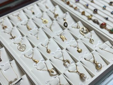 Display of various gold necklaces with pendants in a jewelry store.