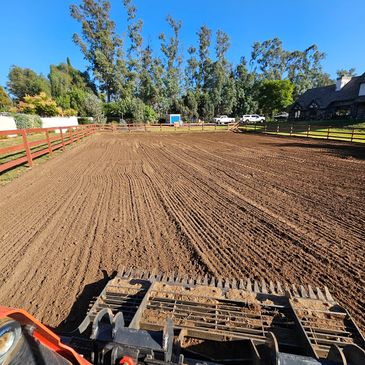 Raking and fluffing up a horse arena.