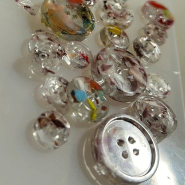 Buttons made from reclaimed surf resin and shredded surf manufacturing waste