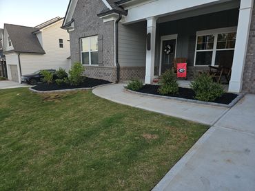 Brick barrier and mulch job done around garden beds