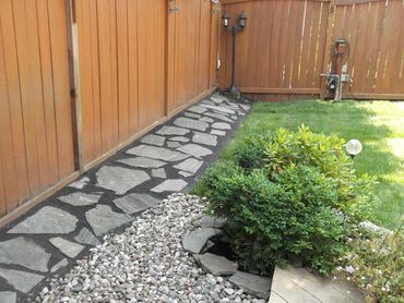 Stone pathway along wooden fence