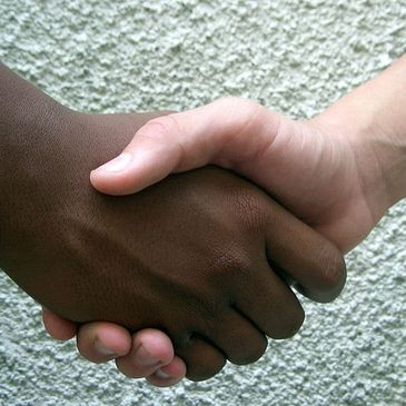 A handshake between two people with different skin tones.