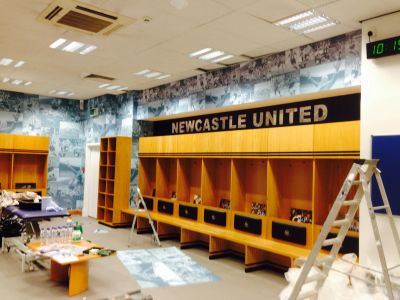 Newcastle United locker room with wooden lockers and ladders.