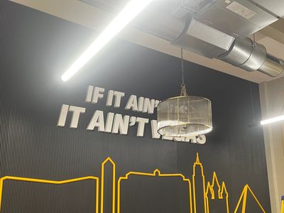 Wall art with phrase and city skyline outline in modern room.