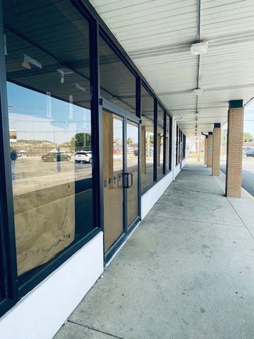 Empty storefronts with windows covered in brown paper.