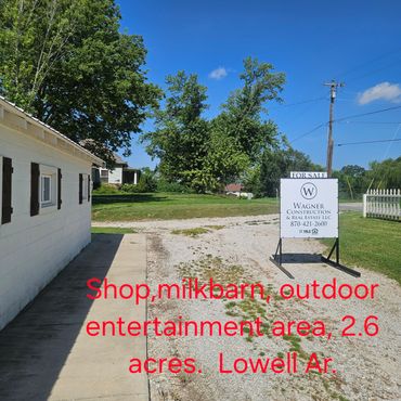 Real estate sign on gravel driveway for sale by Wagner Construction & Real Estate.