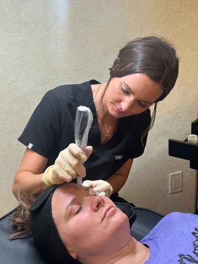 A professional performing a facial treatment on a relaxed client.