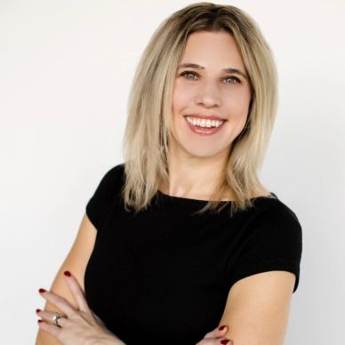 Smiling woman with blonde hair and a black shirt.