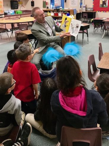 Ian McGaughey reading to local elementary school students