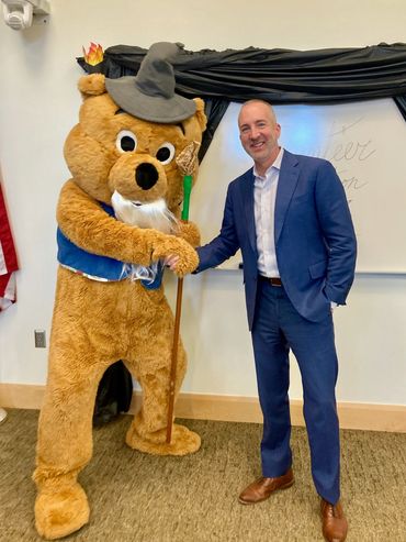 Ian McGaughey shaking hands with Booker the Bear