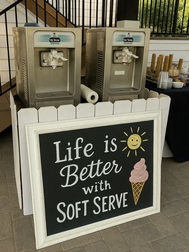 Soft serve ice cream machines with a cheerful sign about life and soft serve.
