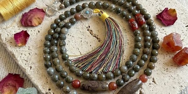 A beaded necklace with a multicolored tassel and decorative stones.