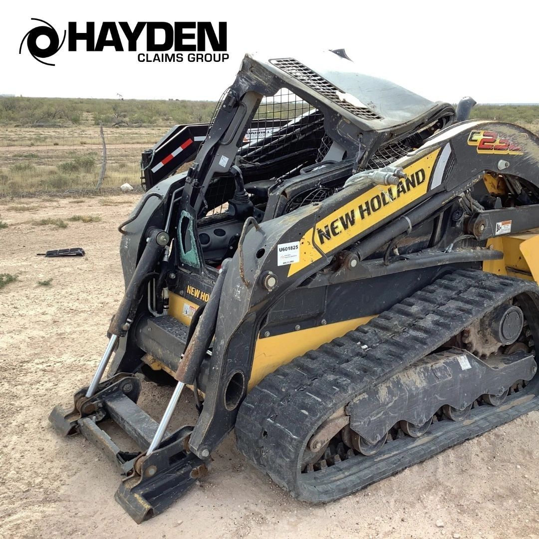 A new holland skid steer with a crushed cab.