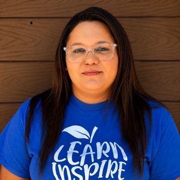 Woman in blue "Learn Inspire" t-shirt with glasses.