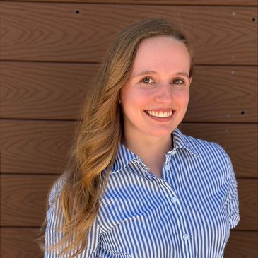 Smiling woman with long hair in striped shirt.
