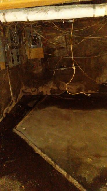 Open panel boxes with loose hanging wires, visible water on floor from cracked foundation.