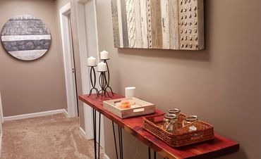 Cozy hallway with decorative candles and textured wall art.
