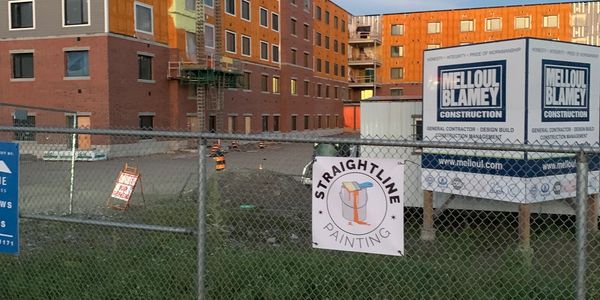 Construction site with signs for Melloul Blamey and Straightline Painting.