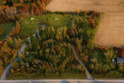 Aerial view of a green wooded area surrounded by fields.