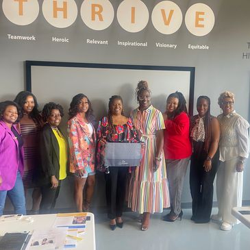 Group of women standing together under the word THRIVE with positive qualities.