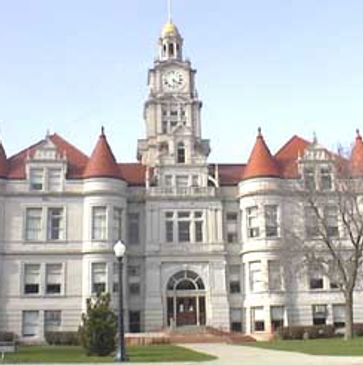 Historic building with clock tower and red-roofed turrets.