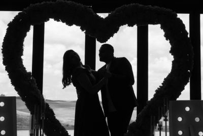Silhouetted couple dancing inside a large heart-shaped frame.