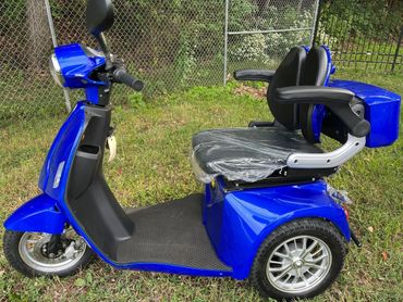 Blue three-wheeled mobility scooter with black cushioned seats.