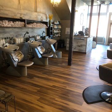 A salon business with a brown wood like vinyl plank floor.