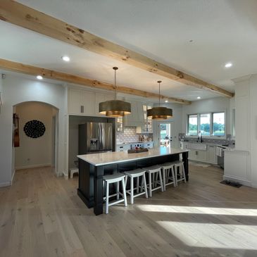 A kitchen with a light color engineered wood floor.