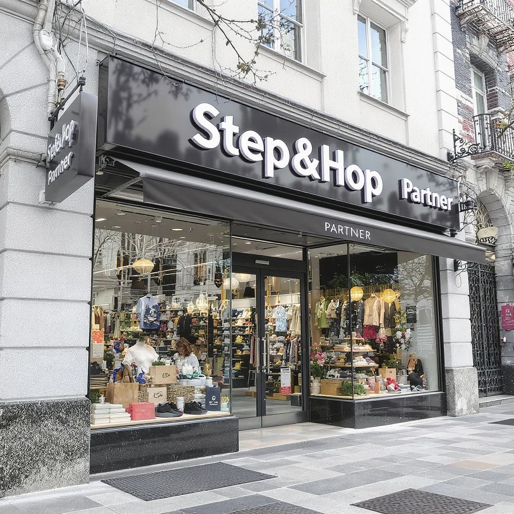 Exterior view of Step&Hop Partner clothing store with glass windows and displays.